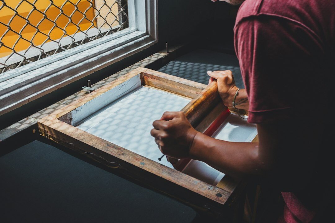 Artisan working with a screen-printing frame by hand